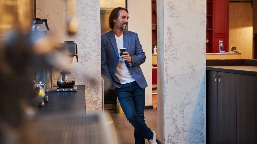 man met koffie aan het werk